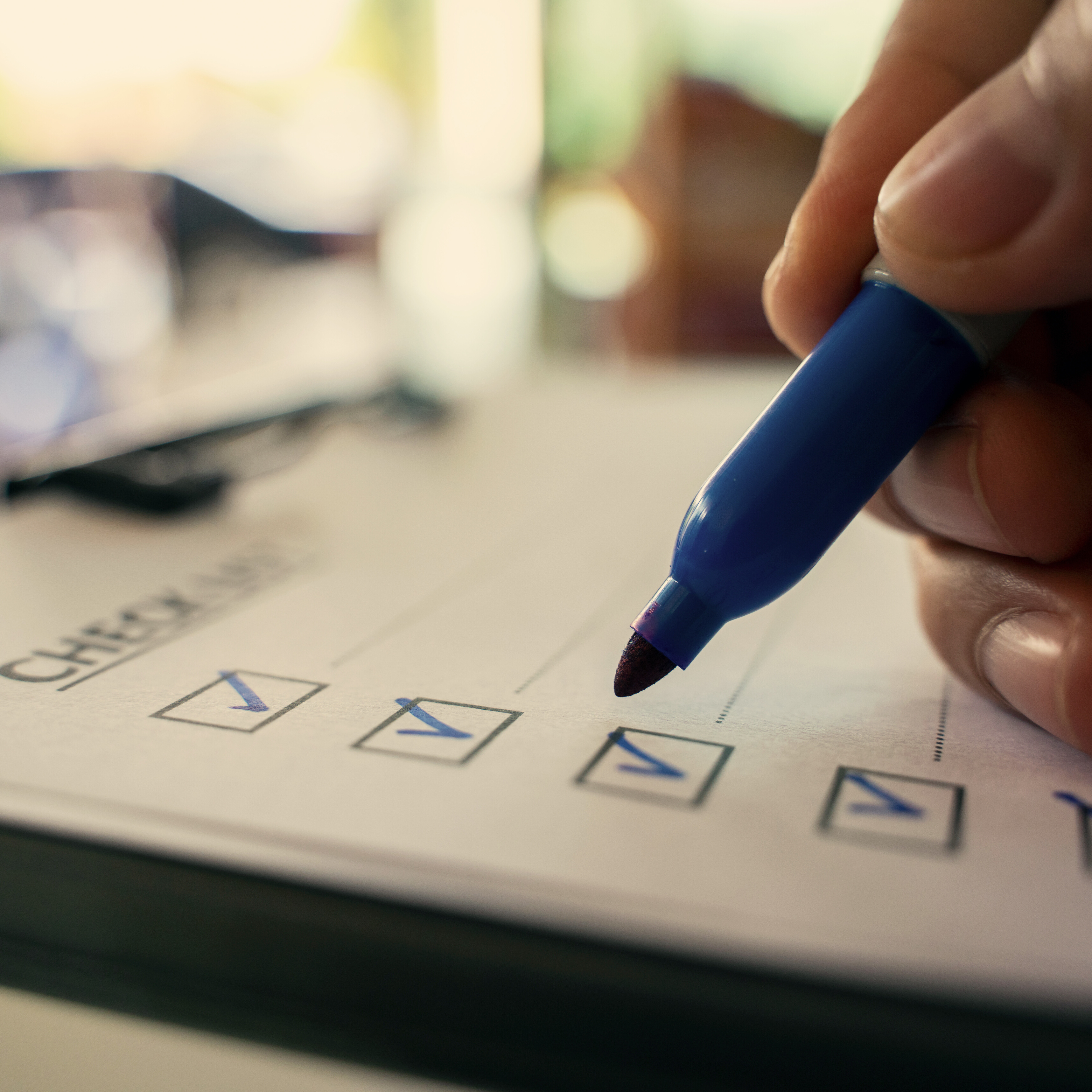 hand with blue pen making on a checklist box