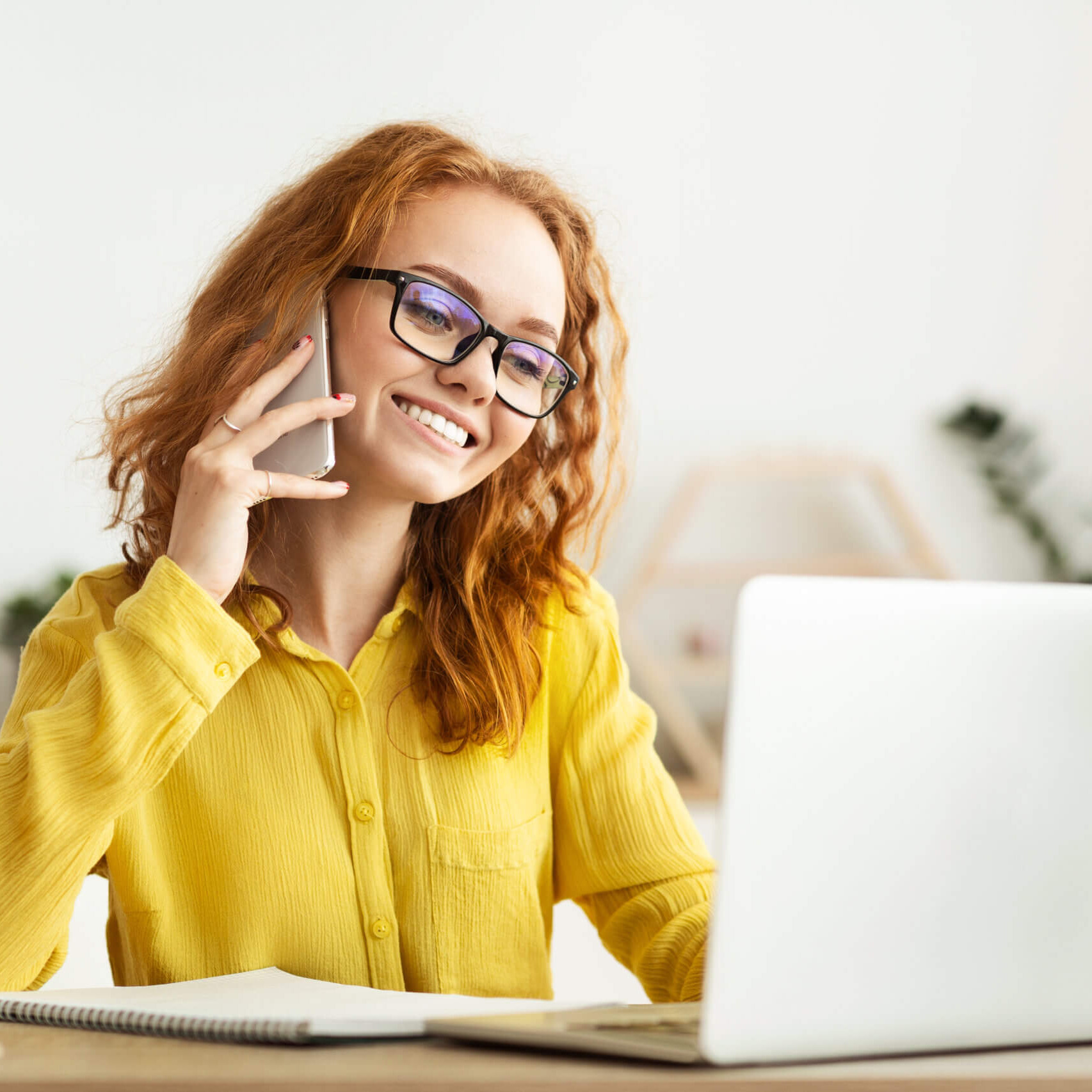 Woman at laptop on phone