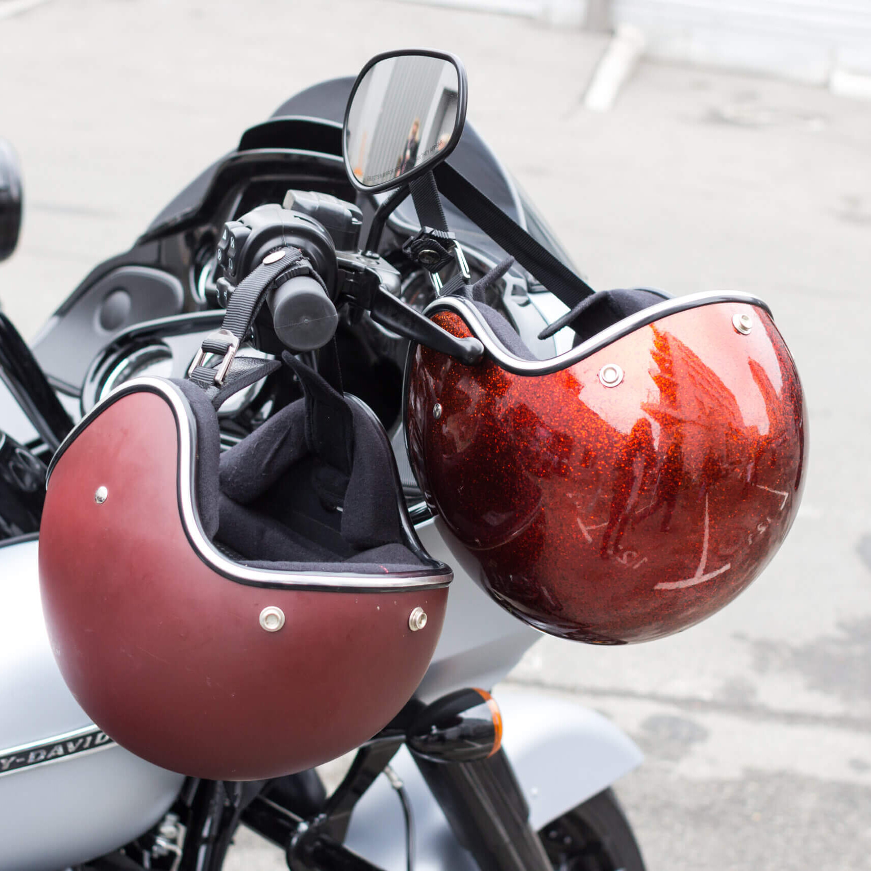 helmets hanging off motorbike handlebars