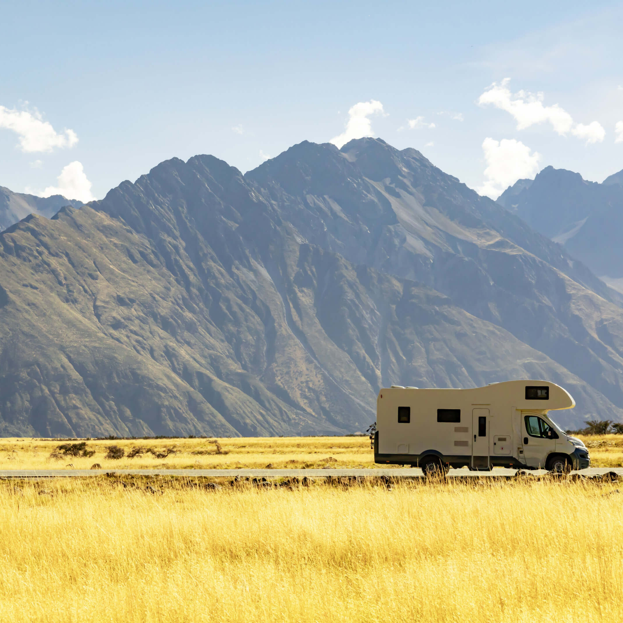 campervan on road with mountains in the background