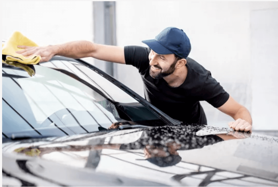 man cleaning car windscreen