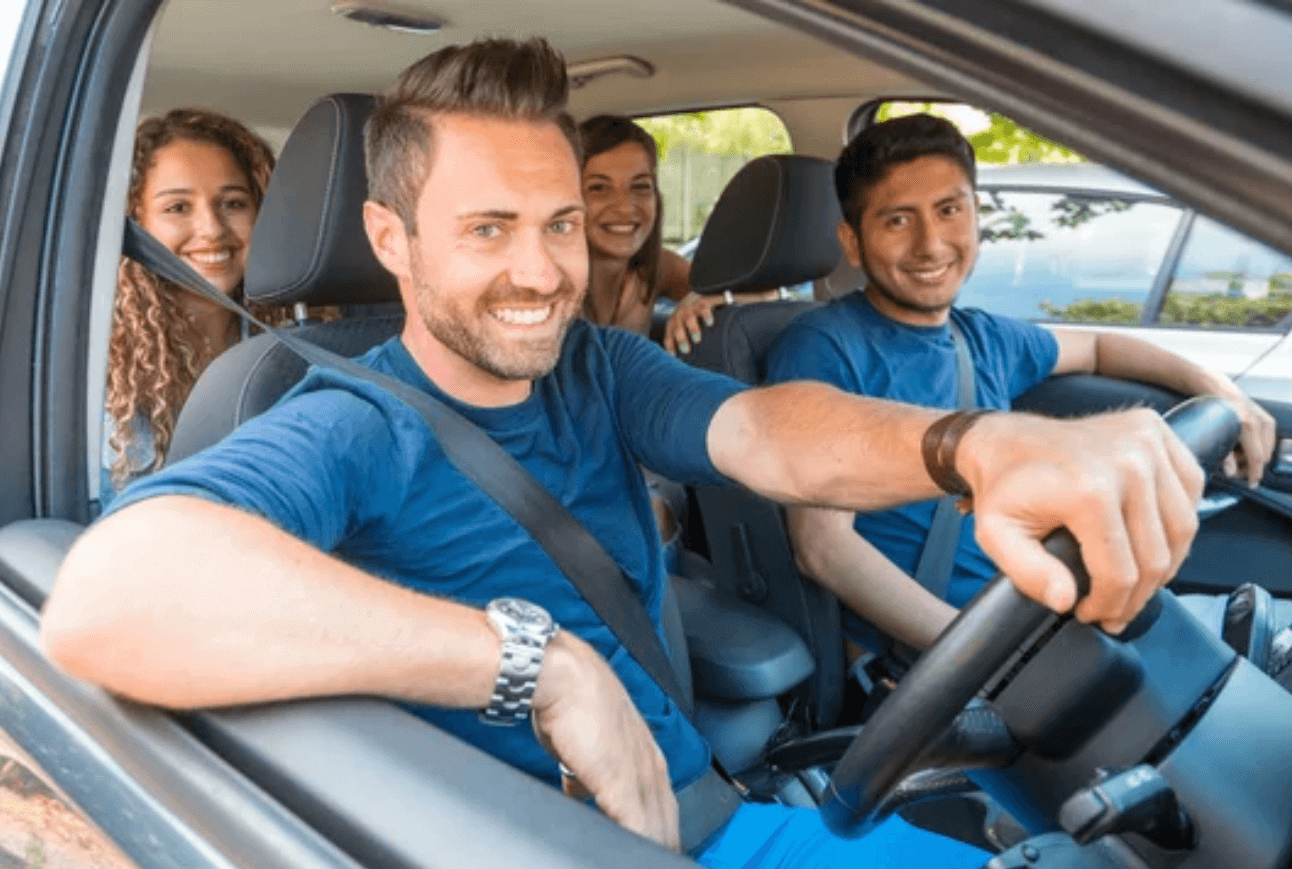 man driving car with friends